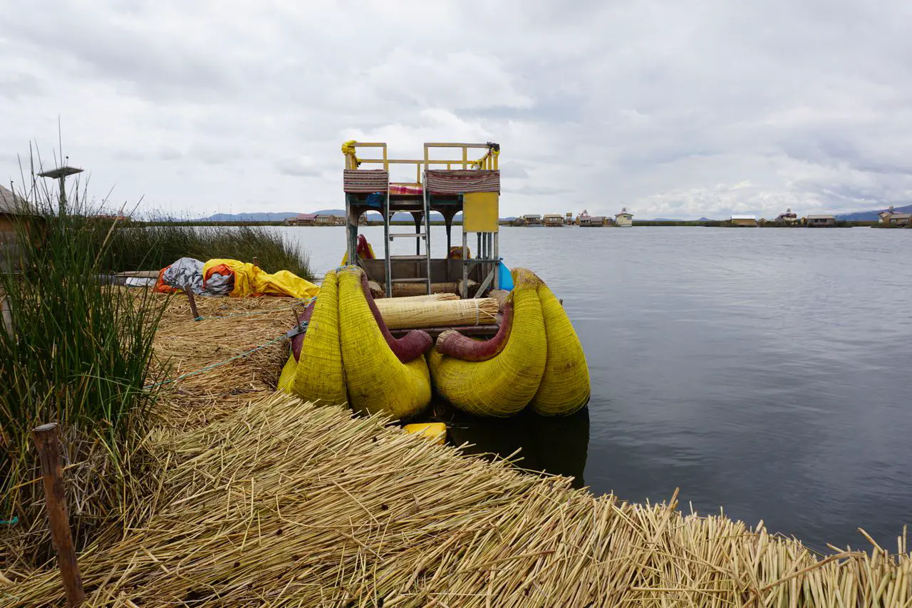 Balsa de totora amarrada junto a una isla flotante de los Uros