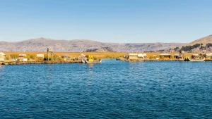 Vista del lago Titicaca con las islas flotantes de los Uros y los cerros de Puno al fondo