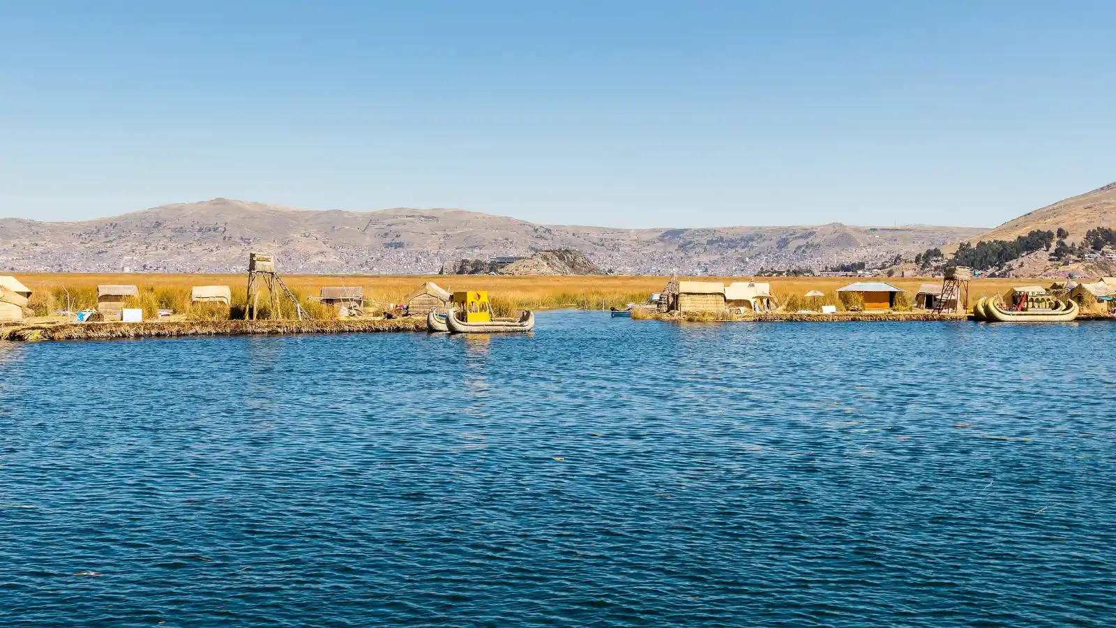 Lake Titicaca with the Uros floating islands and the hills around Puno in the background